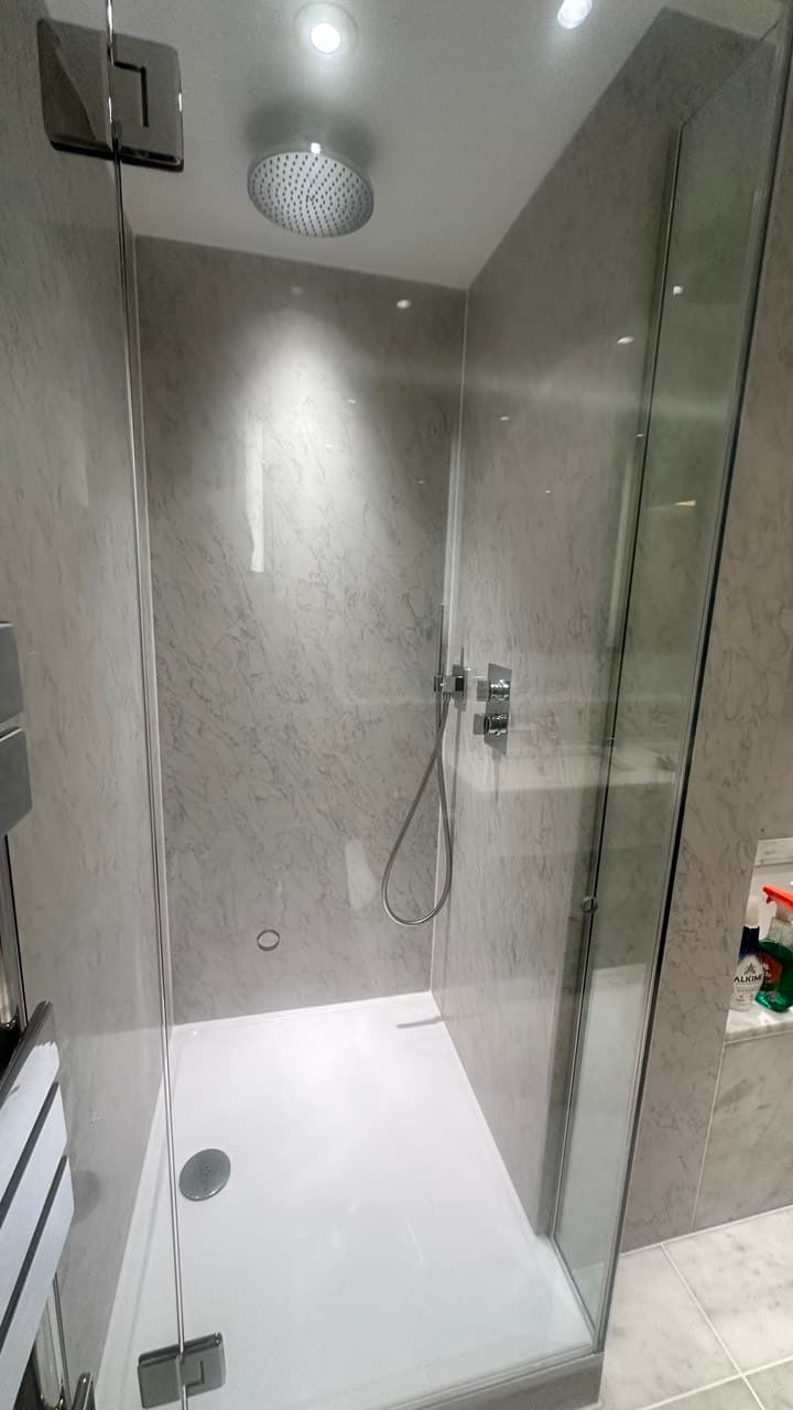Finished walk-in shower with ceiling-mounted rain head and frameless glass