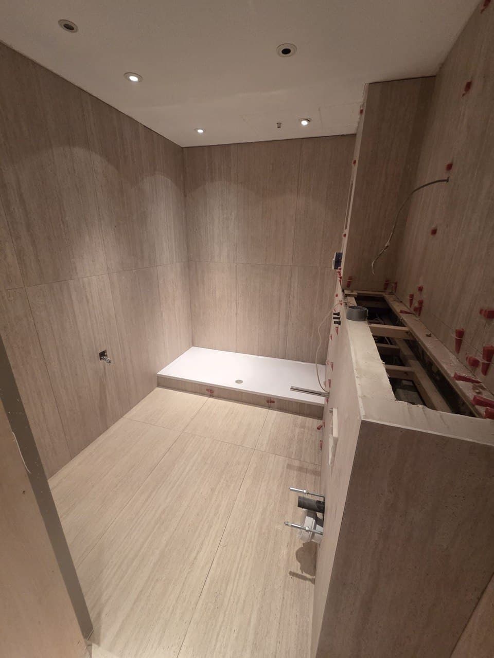 Principal bathroom nearing completion with marble walls and concealed frame in place