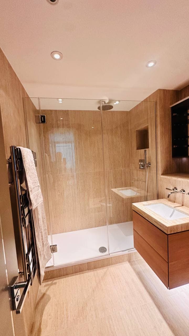 Completed Oslo Court bathroom showing the walk-in shower, towel radiator and vanity unit