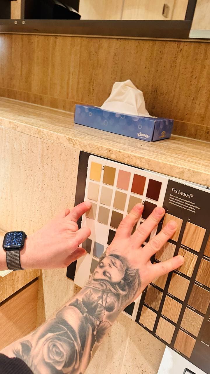 Bathroom finish and colour selection being reviewed against the installed stone-effect surfaces