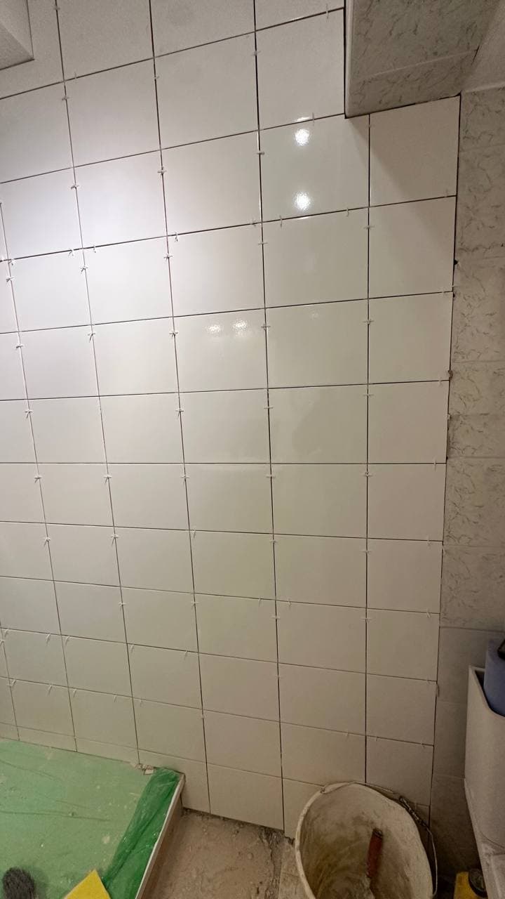 Main wall tiled from floor to ceiling in white gloss ceramic