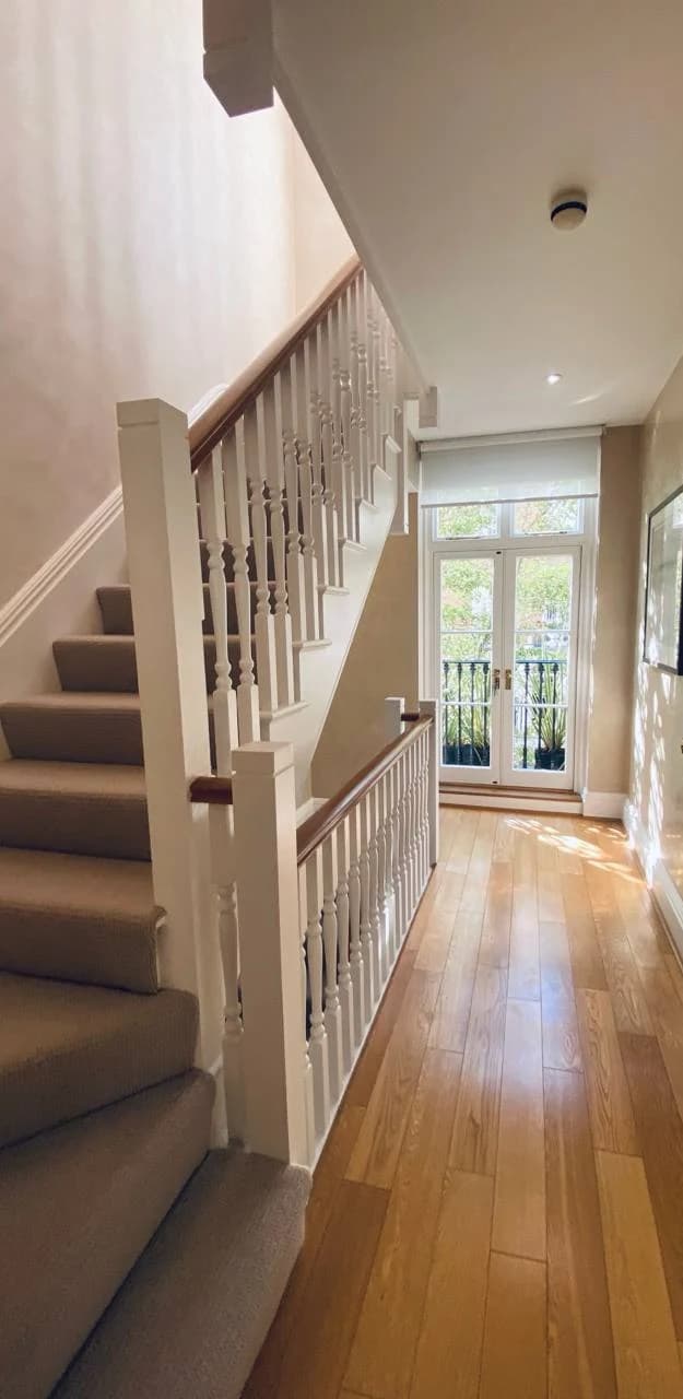 Timber-floored landing with a carpeted staircase and white balustrades